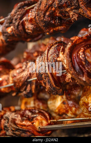 Stinchi di maiale cotte allo spiedo durante una festa del paese Foto Stock