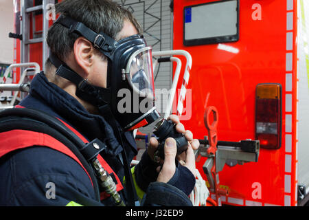 Vigile del fuoco tedesco con maschera in azione Foto Stock