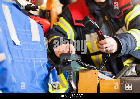 Vigile del fuoco tedesco rigidi in un camion dei pompieri in azione e utilizzato un walkie-talkie Foto Stock