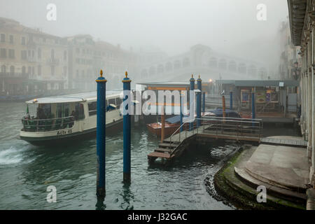 Mattinata nebbiosa sul Canal Grande a Venezia. Ponte di Rialto di telai in distanza. Foto Stock