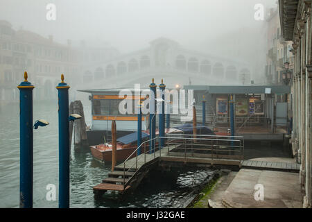 Mattinata nebbiosa sul Canal Grande a Venezia. Ponte di Rialto di telai in distanza. Foto Stock