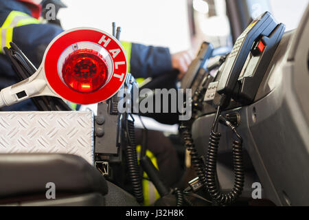 Firefighter aziona un veicolo di emergenza con la comunicazione vista interna e cazzuola Foto Stock