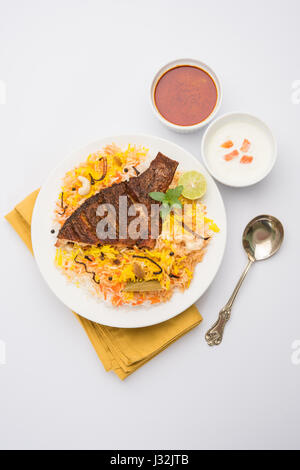 Biryani di pesce o pesce - Riso indiano popolare non vegetariane ricetta a base di pesce marinato con spezie indiane erbe fresche e cotto con riso Basmati, s Foto Stock