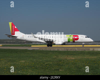 Questa immagine mostra il TAP Express Embraer ERJ-190LR, un jet regionale, che effettua il rullaggio presso l'aeroporto di Schiphol ad Amsterdam, Paesi Bassi. L'aeromobile fa parte della flotta operata da TAP Air Portugal per i voli regionali europei. Foto Stock