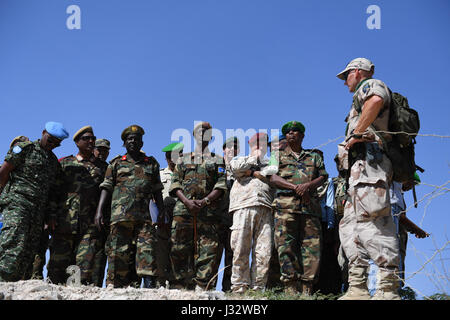 Gli alti ufficiali dai somali Esercito Nazionale (SNA), la missione dell Unione Africana in Somalia (AMISOM) e l'Unione europea alla missione di formazione in Somalia (EUTM), seguire somalo Esercito Nazionale (SNA) i soldati dimostrano campo tattiche militari durante un pass-out cerimonia per segnare la fine della formazione condotta dall' Unione europea alla missione di formazione in Somalia (EUTM) al generale Dhegabadan Training Camp (Jazeera) a Mogadiscio, Somalia il 14 gennaio 2017. AMISOM foto / Omar Abdisalan Foto Stock