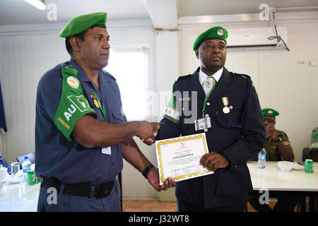 AMISOM commissario di polizia il Brigadiere Anand Pillay presenta un certificato di riconoscimento di Constable David Kinoti durante una medaglie cerimonia di premiazione a Mogadiscio il 18 febbraio 2017. AMISOM foto/Atulinda Allan Foto Stock