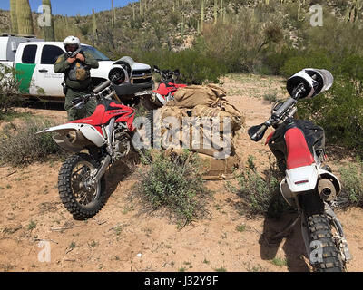 TUCSON, in Arizona - Casa Grande frontiera agenti Patrol arrestati cinque cittadini honduregni domenica mattina, nei pressi del villaggio di Vaya mento sul Tohono O'odham Nation, e sequestrato più di 300 libbre di marijuana che vale la pena in eccesso di $ 150.000. L'incidente si è verificato in una remota area desertica dove gli agenti utilizzando off-road motocicli sono stati sulle orme lungo un noto percorso di contrabbando. Gli agenti seguite le orme di Sierra Blanca montagne e venne su 13 balle di marijuana. Durante una successiva ricerca della zona circostante, agenti che si trovano quattro uomini e un maschio adolescente; tutti i presenti illegalmente in th Foto Stock