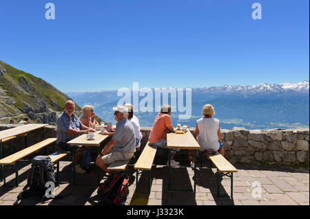 Un gruppo di persone sedute su panche di legno al di fuori del ristorante Hefelekar, Tirolo, Austria Foto Stock