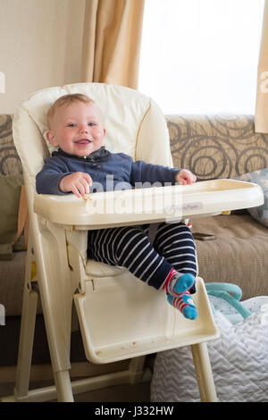 Sette mesi baby boy in una sedia alta, Devon, Inghilterra, Regno Unito. Foto Stock