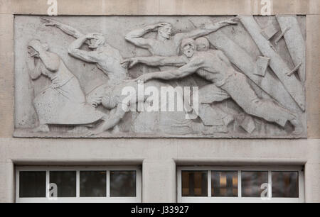 In caso di incidente industriale. Sollievo da scultore ungherese Mihaly Biro sull'ala sud dell'edificio in Art Nouveau di Budapest - i lavoratori del fondo di assicurazione in Budapest, Ungheria. L'edificio, ora utilizzato come sede dell'Assicurazione Sociale Nazionale Centro (OTI), è stato progettato da architetti ungheresi Komor Marcell e Jakab Dezso e costruito nel 1913. L'ala nord è stato aggiunto nel 1930s. Foto Stock