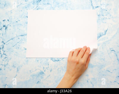 Donna di mano girando sul foglio di carta Foto Stock