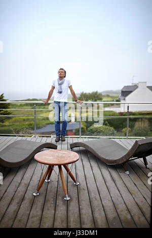L'uomo sulla terrazza della camera di albergo a Hostellerie de la Pointe Saint Mathieu, presso il faro in Plougonvelin, Finisterre, Pays d'Iroise, Bretagna Francia Foto Stock
