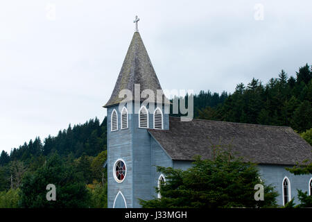 Piccolo centro rurale chiesa provinciale senza eccessi architettonici nella torre e una cupola appuntita con una croce e finestre gotiche con vetrata Foto Stock