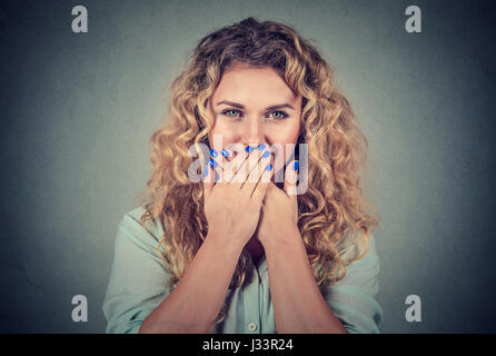 Oops! Sorpreso di giovane donna che copre la bocca con le mani e fissando la telecamera isolata su sfondo grigio Foto Stock