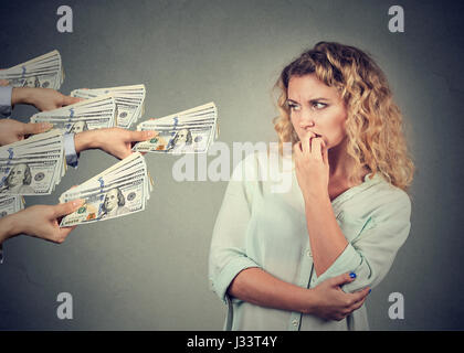 Donna esitante a prendere tangenti da parte di persone Foto Stock