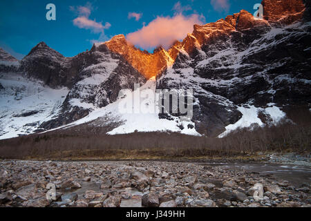 Prima luce sul 3000 piedi verticale Parete Troll e i picchi Trolltindane nella valle Romsdalen, Norvegia. Fiume Rauma è in primo piano. Foto Stock