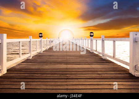 Sun impostare una scena e il vecchio ponte di legno pier con nessuno contro la bella dusky sky utilizzare per lo sfondo naturale ,sfondo e multiuso scena di mare Foto Stock