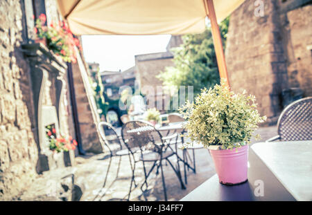 Cafe con tavoli e sedie in una vecchia strada in Europa con retro vintage stile Instagram effetto filtro Foto Stock