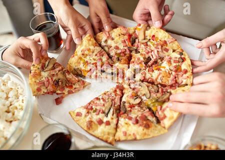 Chiusura del popolo prendendo fette di pizza da box Foto Stock