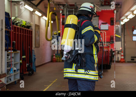 Vigile del fuoco tedesco in azione con serbatoio di ossigeno Foto Stock