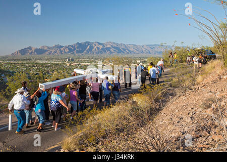 Tucson, Arizona - i partecipanti in una relazione annua di processione del Venerdì santo portano una grande croce fino Sentinel Montagna. La processione si ferma per stazioni della Foto Stock
