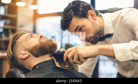 Giovane uomo in Barberia per la cura dei capelli il concetto di servizio Foto Stock