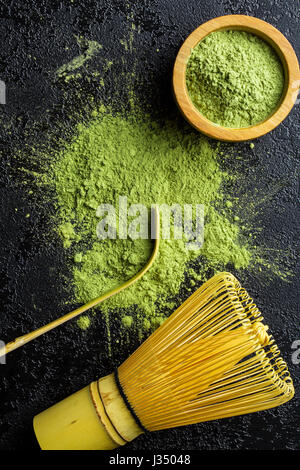 Verde matcha Polvere di tè con frusta di bambù , cucchiaio e ciotola. Preparazione del Tè accessori. Foto Stock