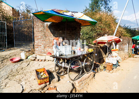 Lo stile di vita locale: tipica strada street tea (chai) ruote stallo barrow da Himachal Pradesh Cricket Stadium, Dharamshala, Himachal Pradesh, India Foto Stock