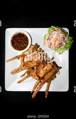 Anatra fritto bocca, piatto di fritte di stagionatura bocca d'anatra su sfondo nero Foto Stock