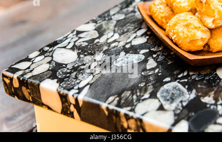 Vista prospettica di pane all'interno di treccia di legno sulla cucina moderna in bianco e nero del piano del banco in granito. Foto Stock