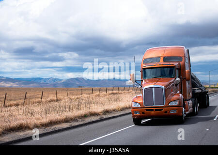 Elegante e moderno semi un carrello con cabina alta per il resto del conducente spostando sull'autostrada con un pianale rimorchio dove il carico viene fissato mediante imbracature Foto Stock