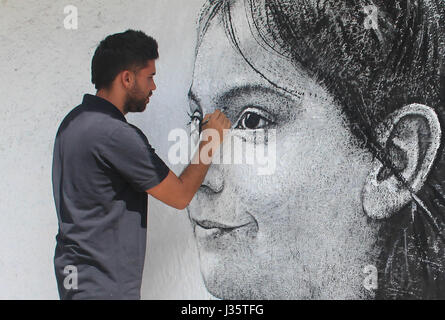 L'Avana, Cuba. 24 apr, 2017. L'artista di strada Maisel Lopez disegna il volto di un bambino su una parete in Havanna, Cuba, 24 aprile 2017. L'artista cubano mira a portare l'arte per le strade con il suo lavoro "Los Colosos' (spagnolo per "l'Giantss'). Foto: Guillermo Nova/dpa/Alamy Live News Foto Stock