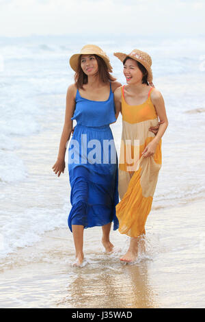 Ritratto di giovane donna asiatica con felicità emozione indossando abiti belle passeggiate sulla spiaggia del mare e ridere gioioso impiego per le persone vacanza rilassante Foto Stock