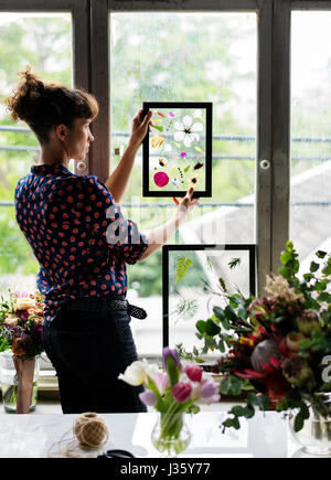 Rendendo i fiori secchi nel telaio di vetro fatti a mano Hobby Foto Stock