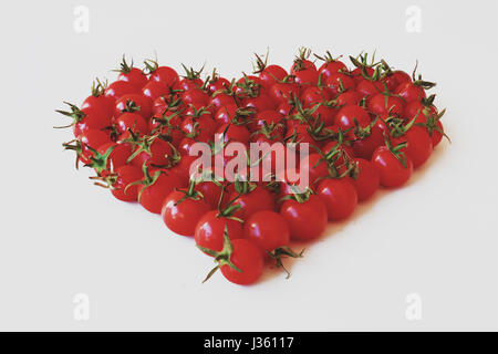Delizioso e sano i pomodori ciliegia ecologicamente cresciuto, disposte a forma di cuore Foto Stock