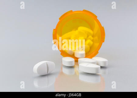 Pills fuoriuscita da un vaso aperto su sfondo bianco Foto Stock