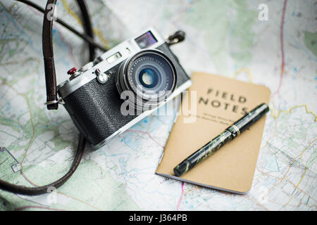 Fuji x100 fotocamera sulla mappa con il campo Note e notebook green Mabie Todd vintage fountain pen. Foto Stock