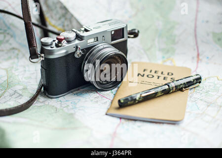 Fuji x100 fotocamera sulla mappa con il campo Note e notebook green Mabie Todd vintage fountain pen. Foto Stock