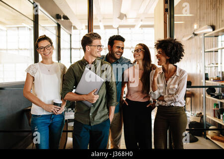 Ritratto di business di successo di squadra in piedi insieme e sorridente. Multi etnico la gente di affari all'avvio. Foto Stock