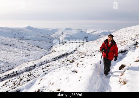 Donna indiana escursionismo in inverno la neve, Peak District, REGNO UNITO Foto Stock