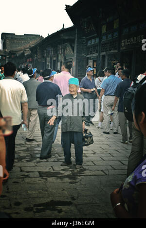 Il vecchio donna cinese a piedi sulla strada di Pingyao,central nella provincia dello Shanxi in Cina. Foto Stock