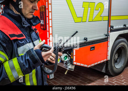 Vigile del fuoco utilizzato un walkie talkie in azione - HDR Foto Stock