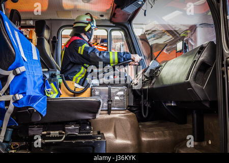 Firefighter aziona un veicolo di emergenza con la comunicazione vista interna - HDR Foto Stock