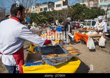 La preparazione di grigliate di sgombro panini in una fase di stallo sul lungomare di Karakoy, Beyoglu, Istanbul, Turchia. Foto Stock