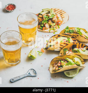 Sana tortilla di mais con la birra in bicchieri su sfondo chiaro Foto Stock