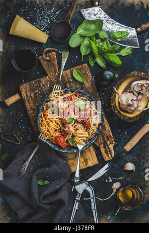 Spaghetti con pomodoro e basilico e gli ingredienti per fare la pasta Foto Stock