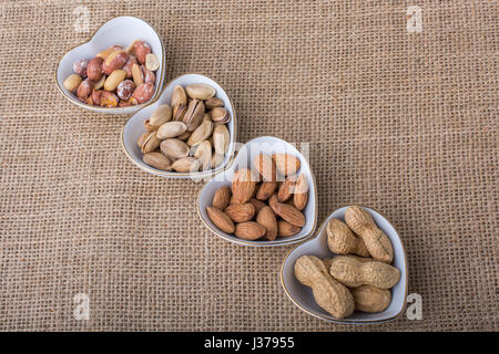 Arachidi, mandorle, pistacchi nel cuore piastre sagomate su tela Foto Stock