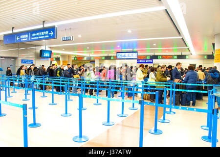 SHANGHAI, Cina - 26 DIC 2106: persone all'Aeroporto di Shanghai Pudong arrivo contatore di immigrazione. Dall'Aeroporto di Pudong è un importante hub di aviazione della Cina Foto Stock