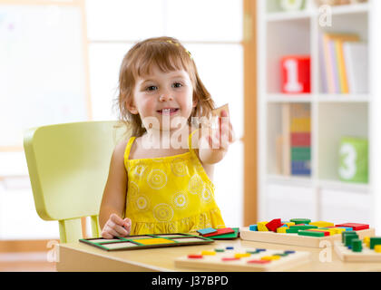 Kindergarten bambino gioca nel fascicolatore a tavola Foto Stock