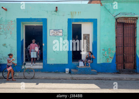 Strada locale vita in Trinidad, Sancti Spiritus, Cuba. Gente radunata davanti a un negozio. Foto Stock